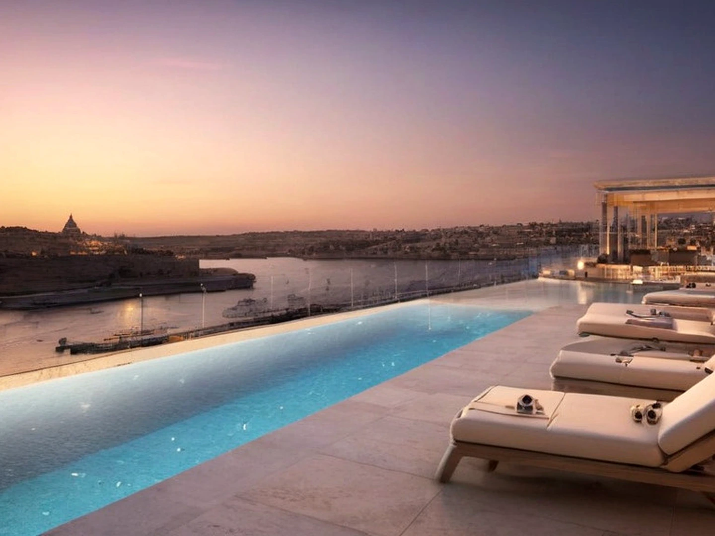 Luxury infinity terrace resort with waterfront horizon, detailed pool edge, sun loungers, and premium evening light